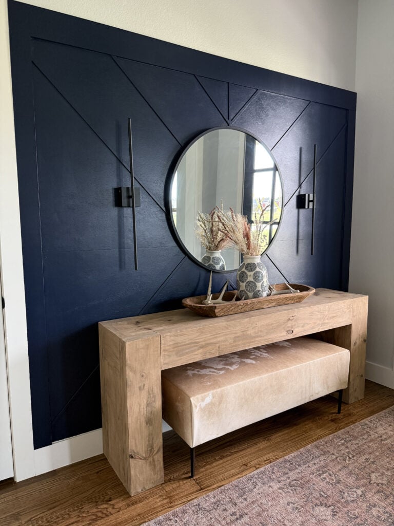 Custom cowhide upholstered bench styled behind a living room sofa.