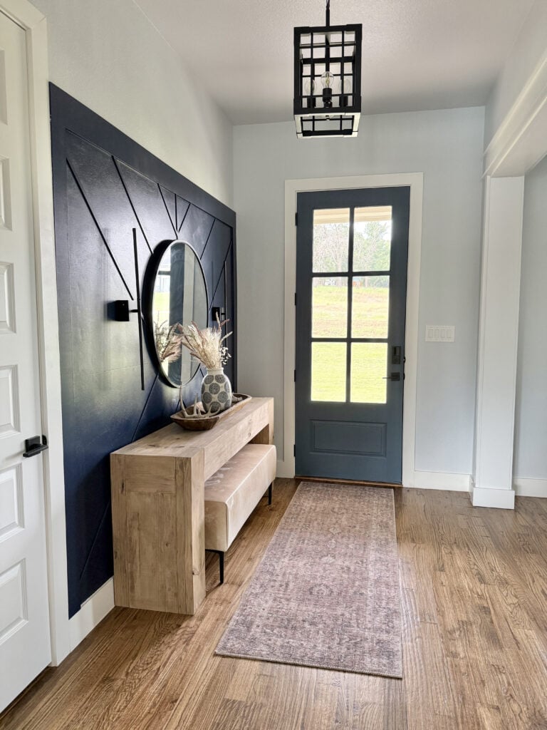 Finished DIY cowhide bench with metal legs styled in an entryway.