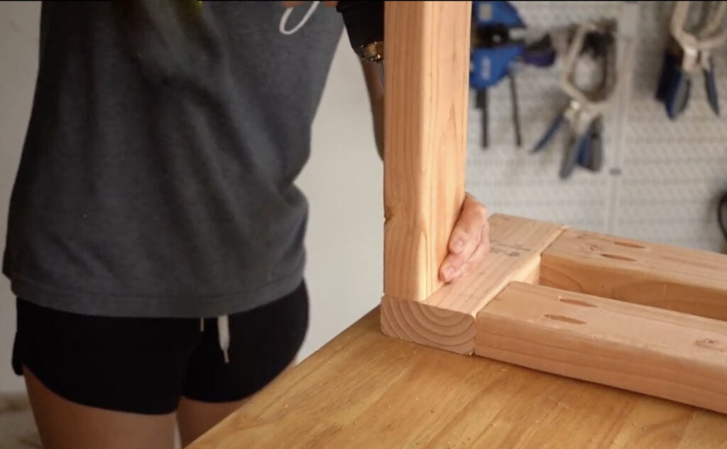 Attaching a long frame piece to the side assembly of the DIY cowhide bench.